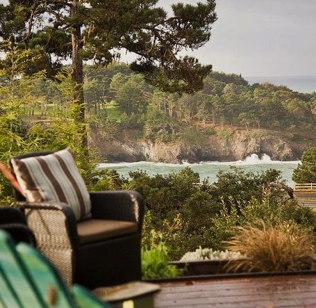 A view of the waves crashing against the shore seen the wooden deck at Brewery Gulch Inn & Spa