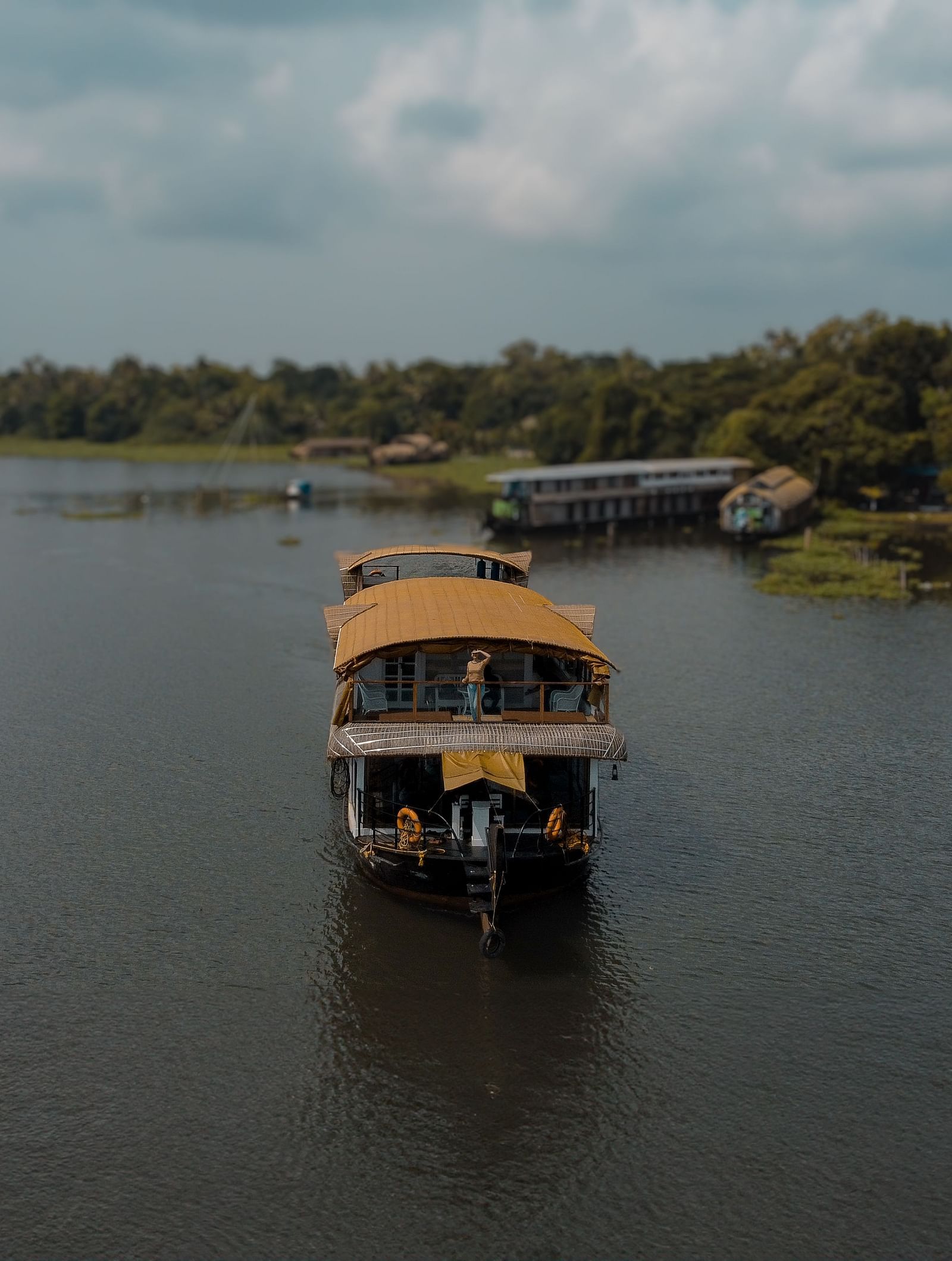 A cruise sailing across the Vembanad Lake with lush greenery in the background - BluSalzz Villas - Muhamma Resort, Alleppey