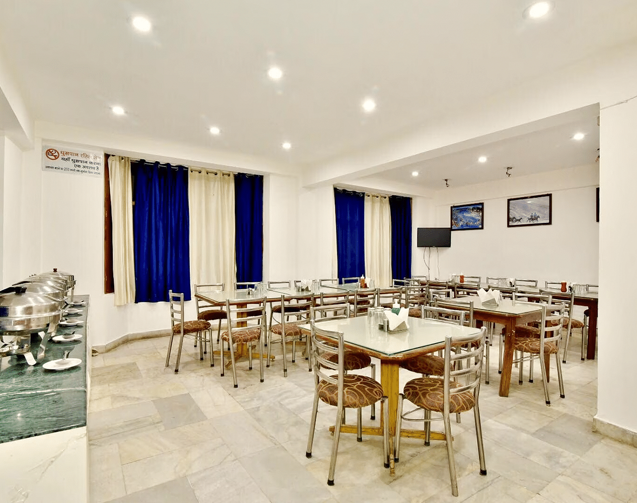 Well-lit interiors of the restaurant at DLS Hotel Devlok, Manali with the buffet arrangement towards the side