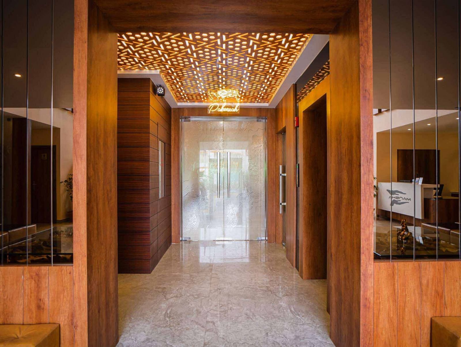 The elegantly designed entryway of Mansha Palace features wooden accents, mirrors, and warm lighting.