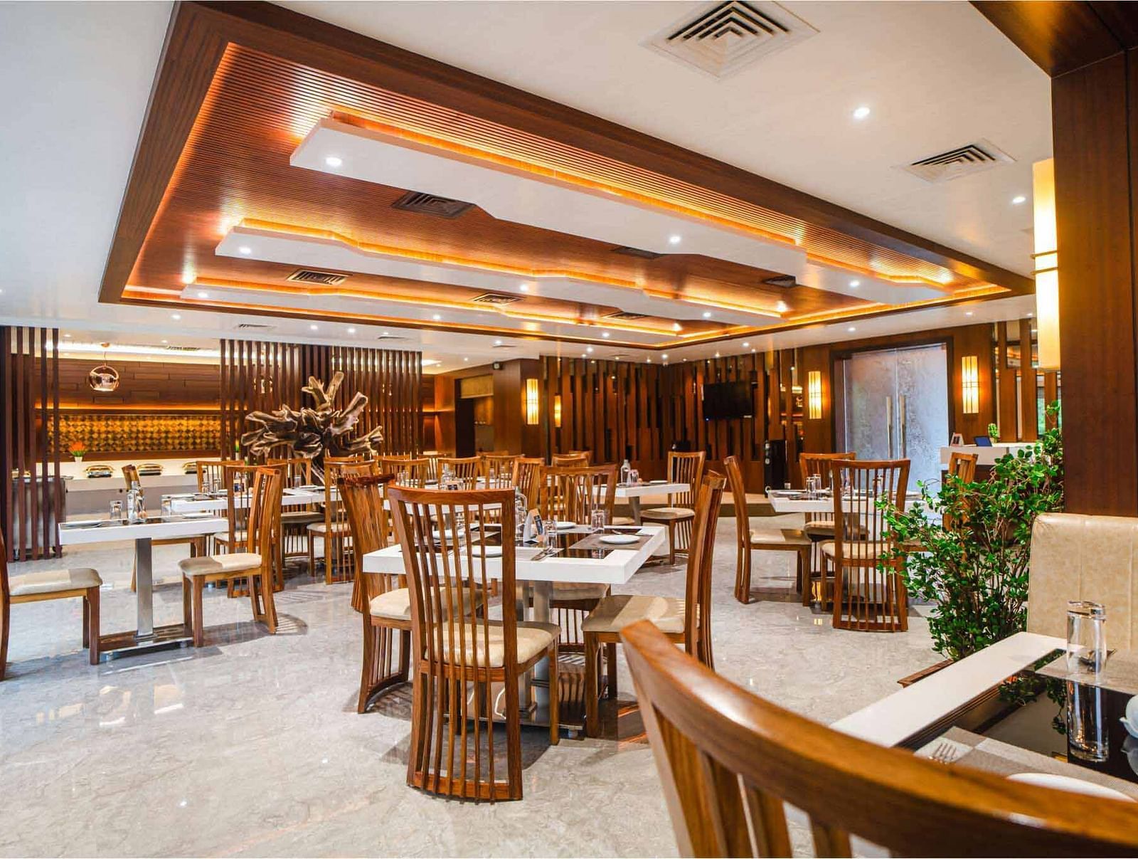 The inviting dining space at Pakeezah Restaurant, Mansha Palace features elegantly set tables and comfortable wooden seating.