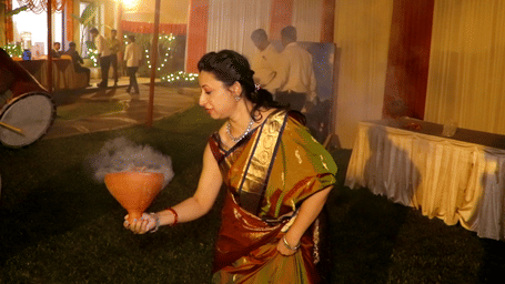 A woman in traditional attire participating in dance performance inside a decorated venue.