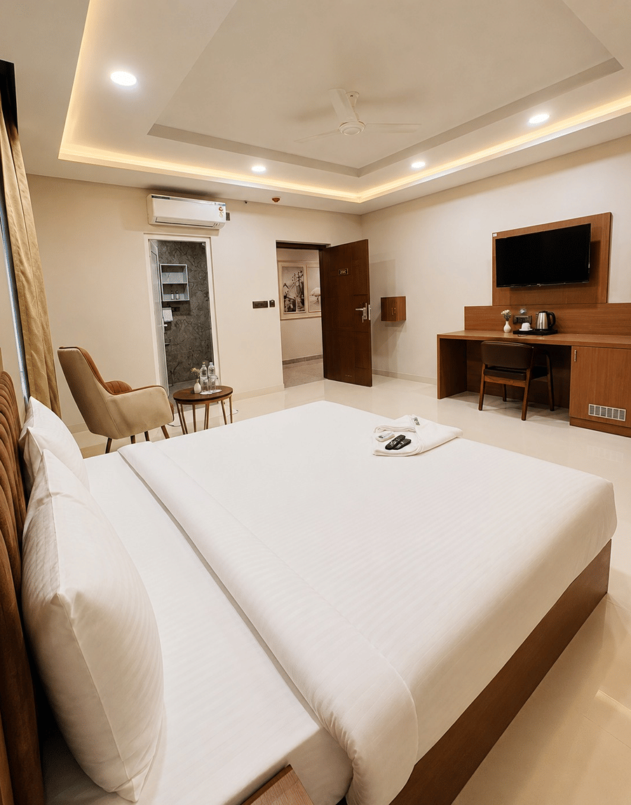 Overhead view of the Jal Mahal Deluxe Room double bed facing a wall-mounted TV at Lime Tree Hotel & Banquet, Jaipur