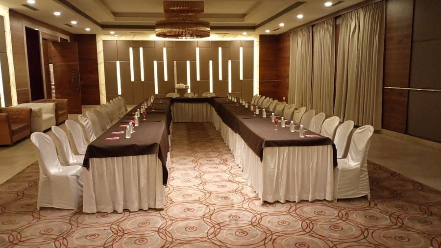 A formal meeting room at Rang Lords Inn, with a long conference table and arranged chairs, ready for business meetings or presentations 