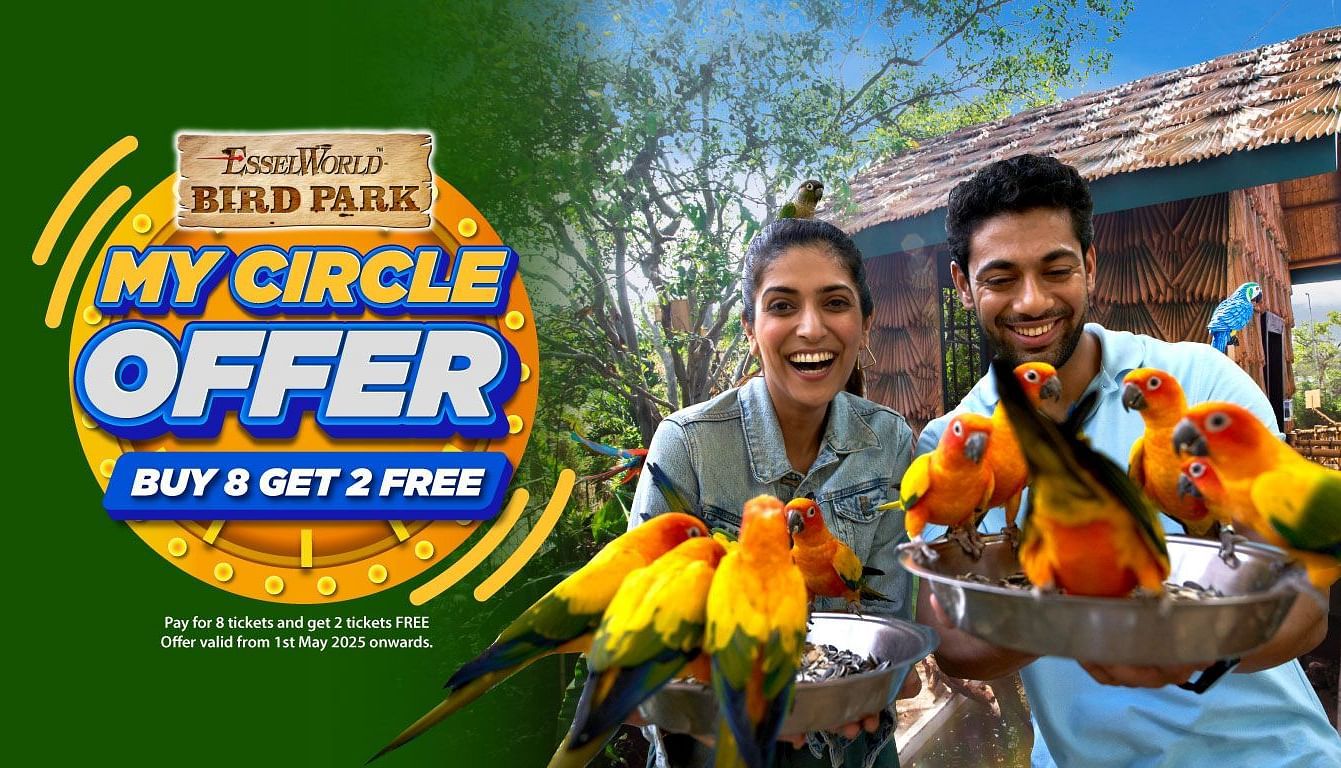 Group of smiling visitors interacting with colorful birds at a bird park under a promotional offer banner