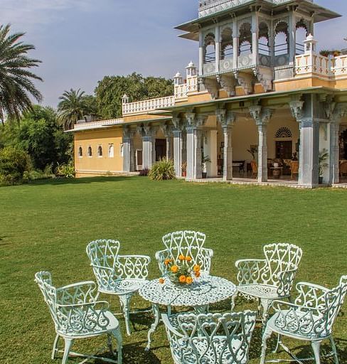 facade image of Dev Shree during the day with an outdoor seating area in the foreground