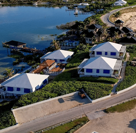Aerial view of coastal houses near the beach, including green lawns and palm-lined pathways | Abaco Inn