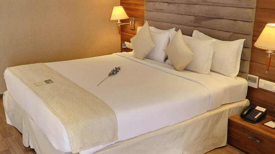 Bed with white sheets and a cream bed scarf