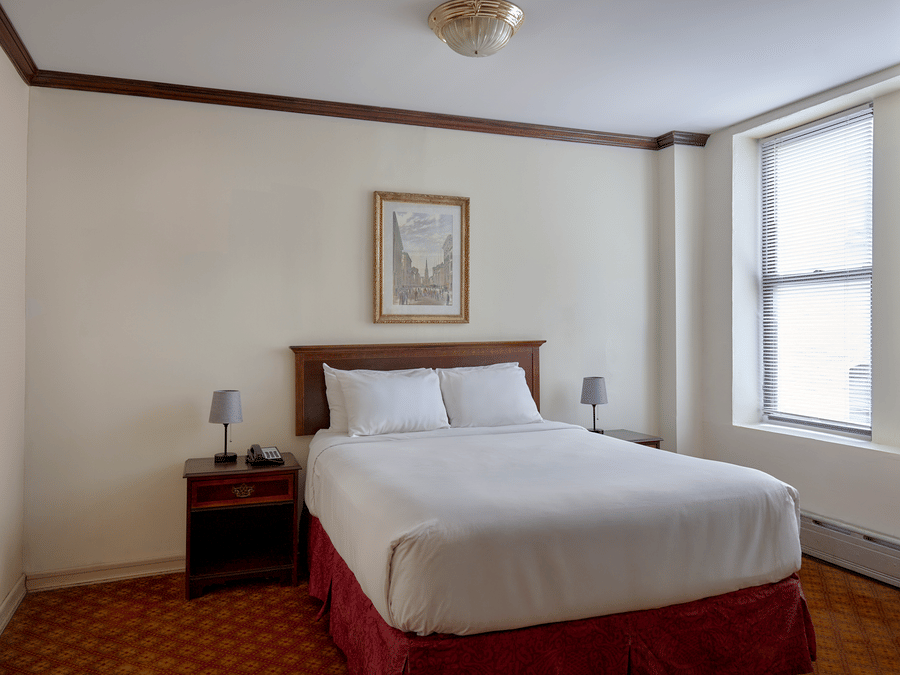 Room at Night Hotel Broadway showing a bed, framed wall art, and window near the corner.