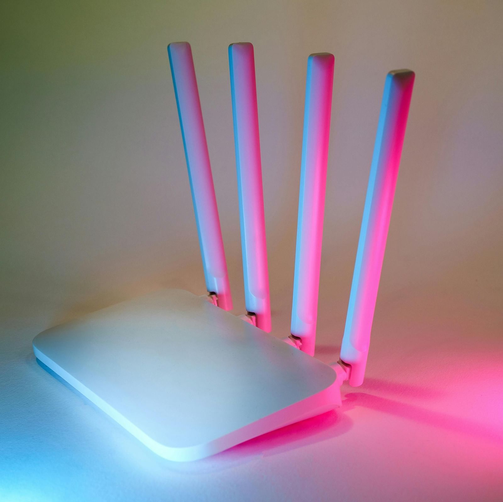 A white router placed on a whiteboard with pink and blue rays of light flashing on it.