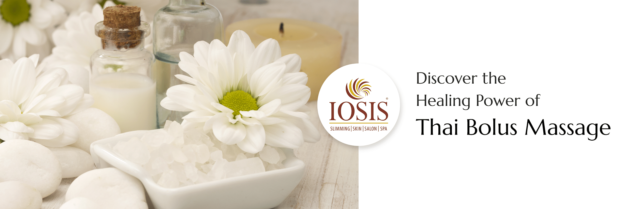 Various kinds of oils and liquids kept on a table of massage centre with flowers