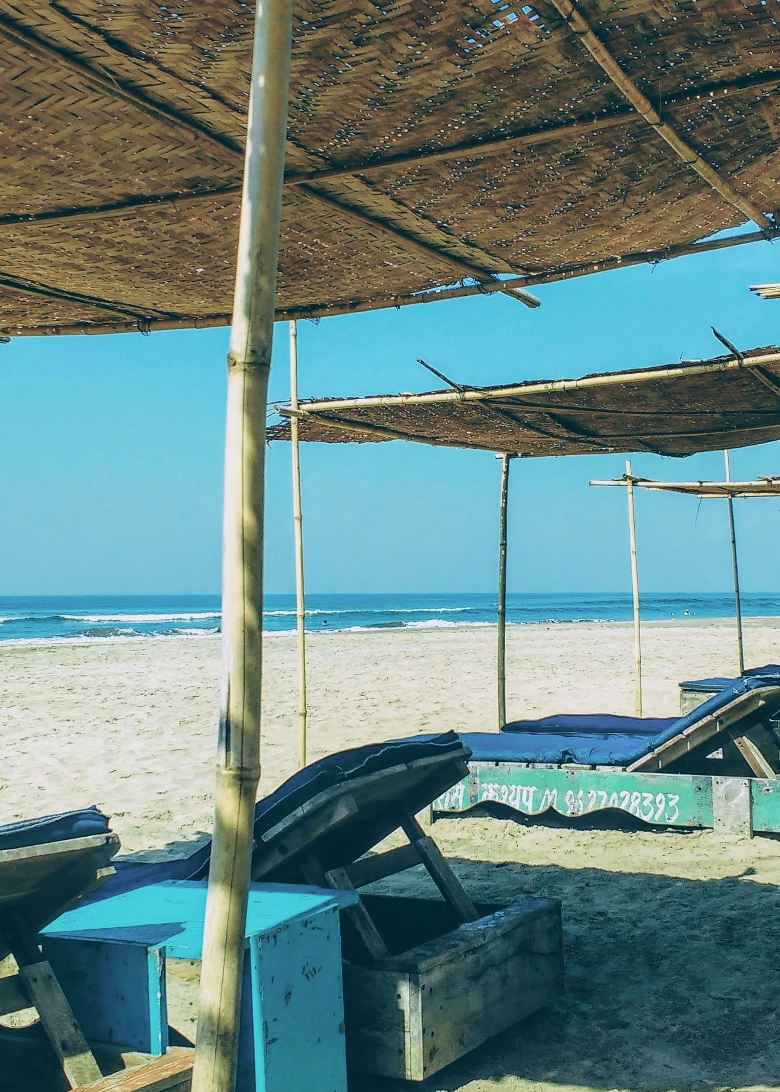 beach shacks with sunbeds under it on the beach