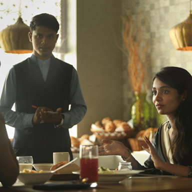 two women dining at our cafe and a waiter standing beside them at The Residency Towers Rameswaram