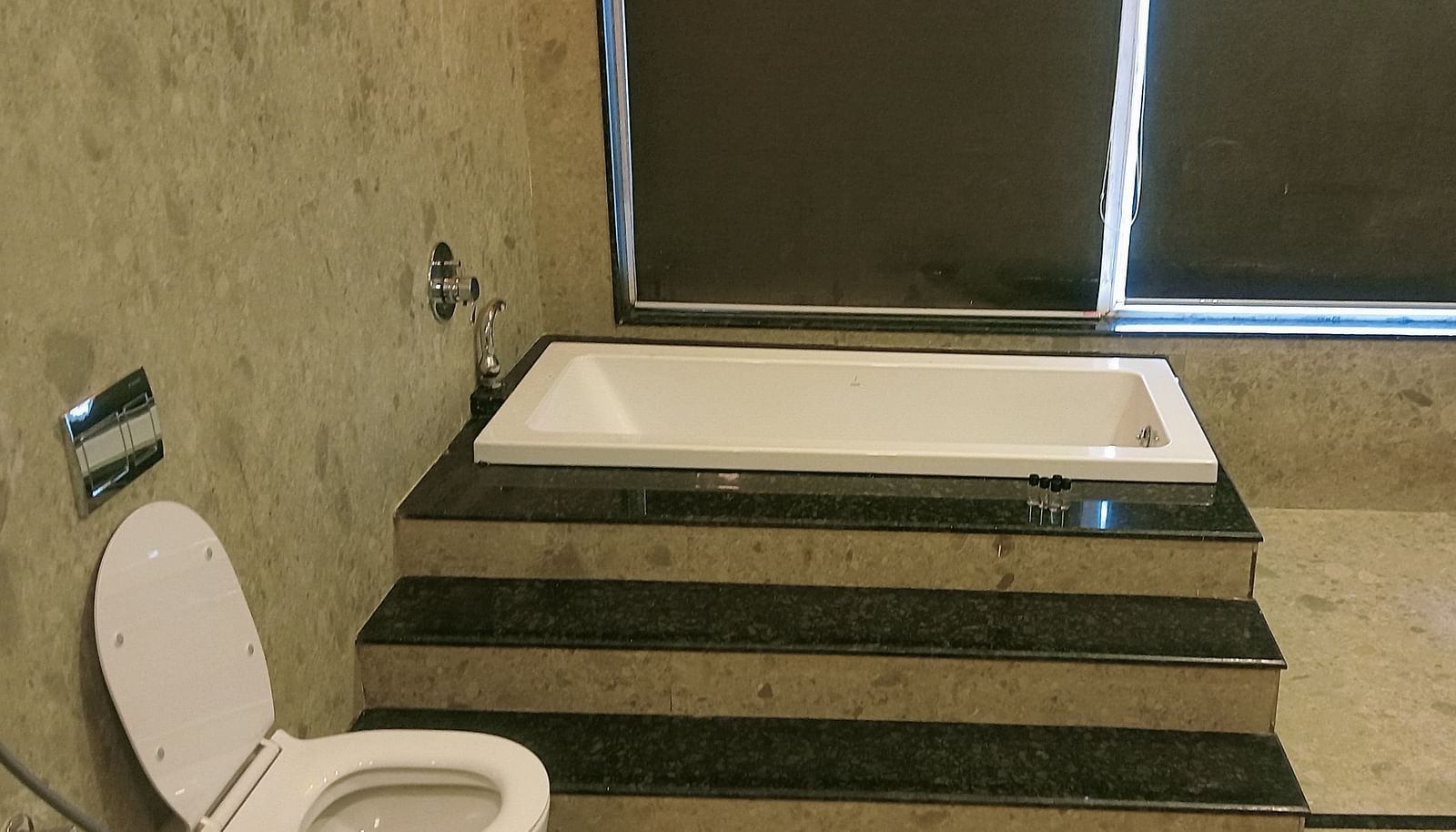 image of the bathroom of the artist suite featuring a bathtub an d a commode besides it