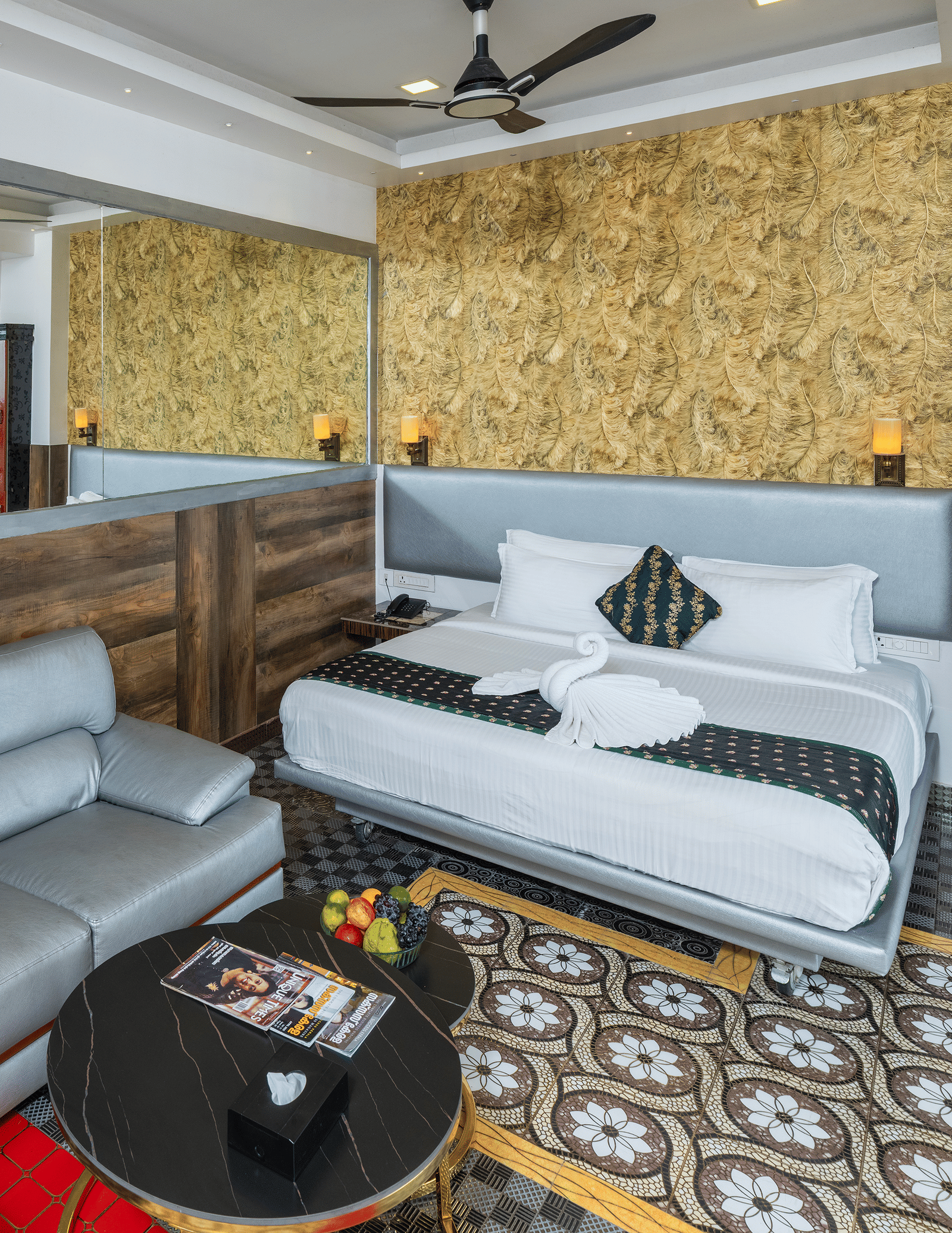 A bedroom in 2 Bedroom Pool Villa at Parakkat Nature Hotel and Resorts, Munnar, featuring a double bed, a 2 seating sofa, a round table, and patterned tiles.