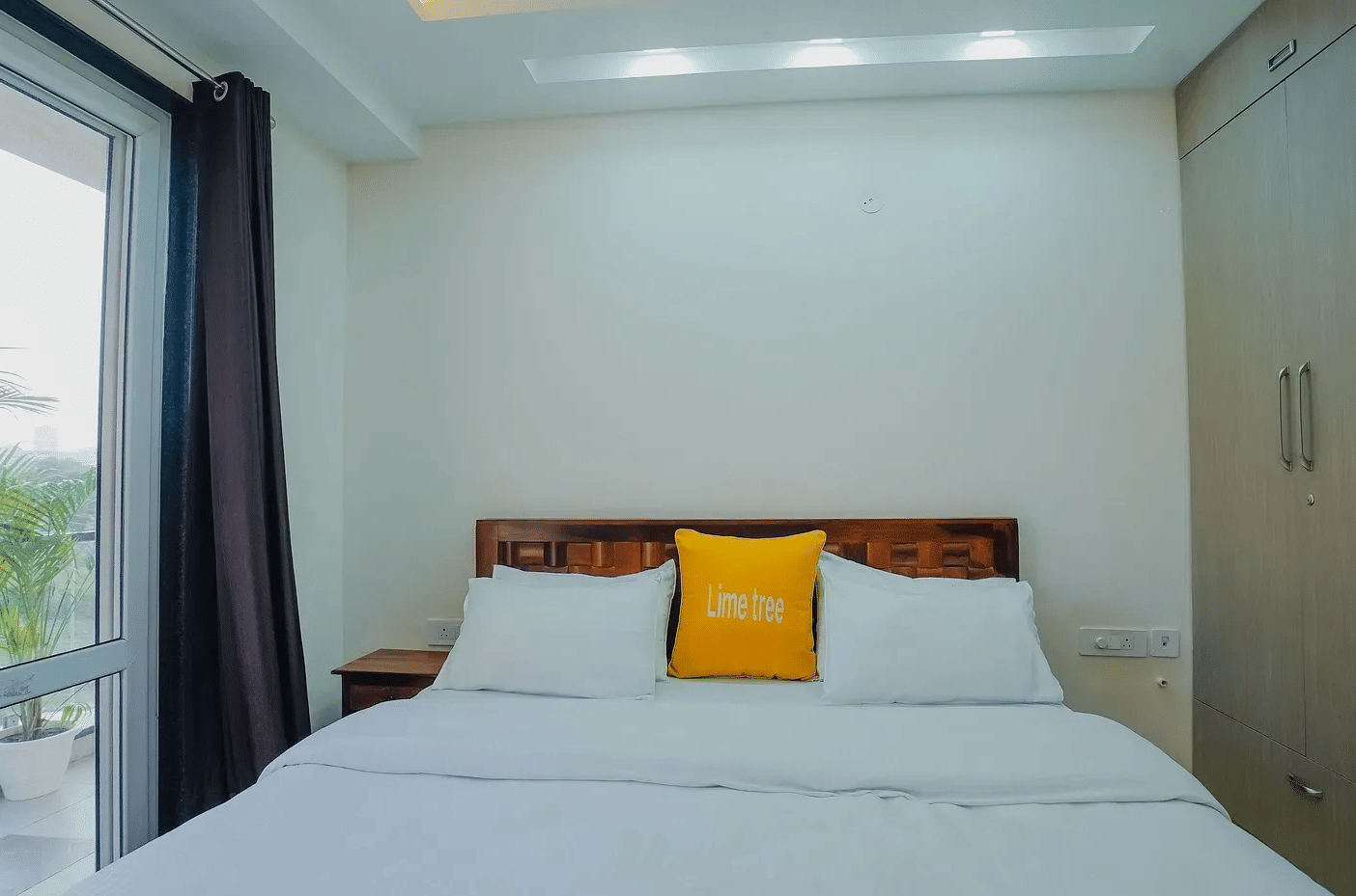 Lime Tree Hotel Golf Course Extension Road Gurgaon - Double with pillows and balcony door on the side