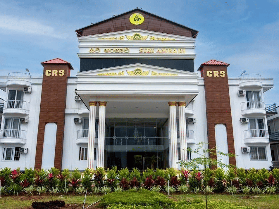 Grand exterior view of Siri Ambari Resorts and Spa, featuring a majestic white building with landscaped gardens in front.