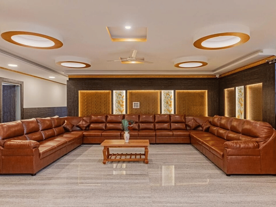 Luxurious lounge space with brown leather sofas, circular ceiling lights at Siri Ambari Resorts and Spa.
