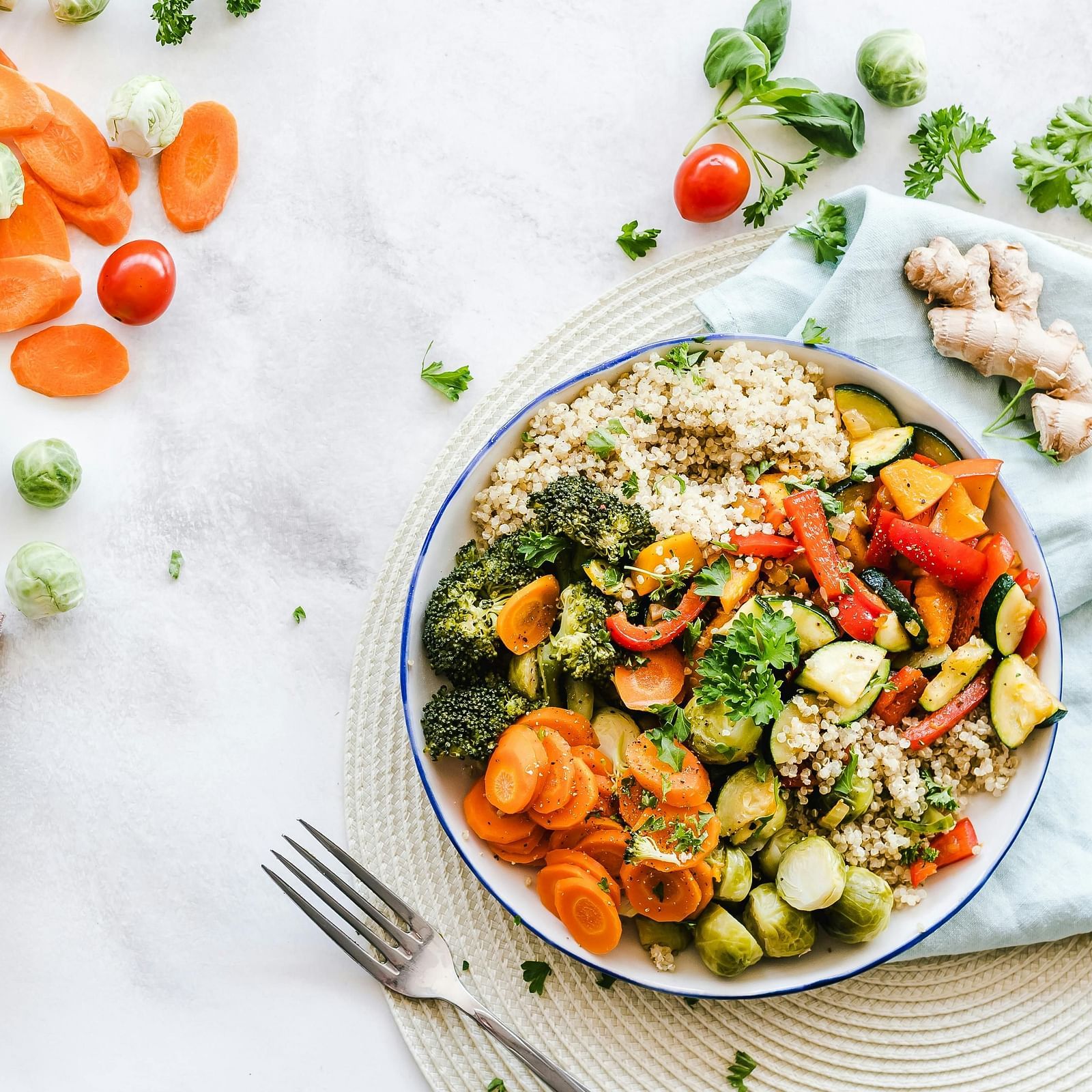 Salad bowl with vegetables, fork and napkins