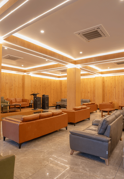 A shot of banquet hall at Summit featuring comfortable sofas of diffrent colours and a well lit surronding.