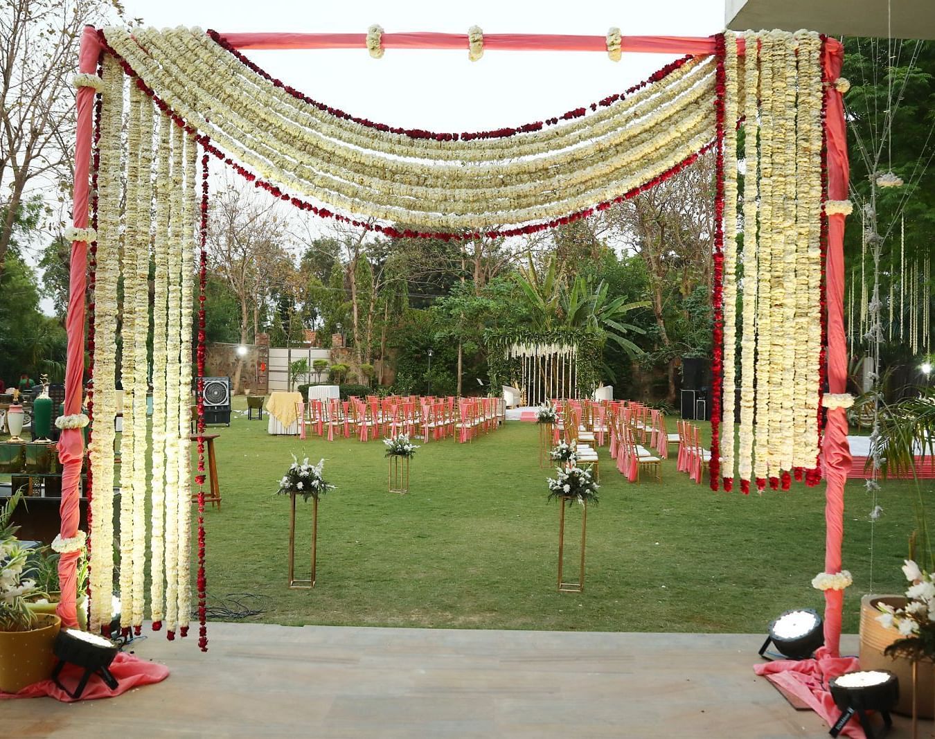 Entrance gate at Tisya Farms, Gurgaon decorated with fabric, lights, and flowers in a symmetrical arch.