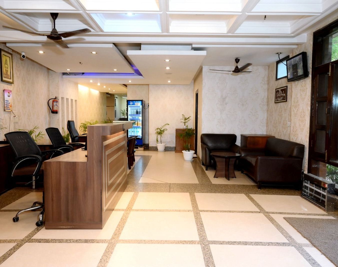 A welcoming hotel reception with a front desk, sofas, and decorative lighting - Hotel Diamond Inn, Chandigarh