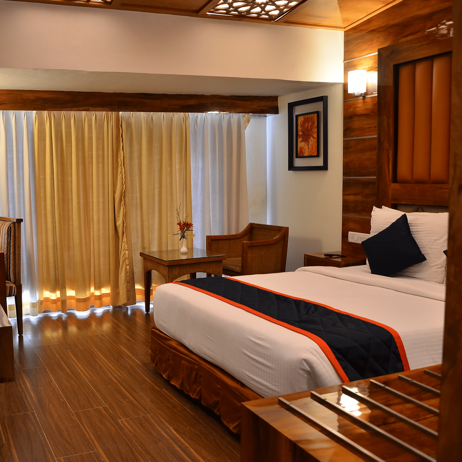 A premium room featuring balcony access, cosy lighting, and wooden flooring for a classy ambience - Benzz Park, Kodaikanal
