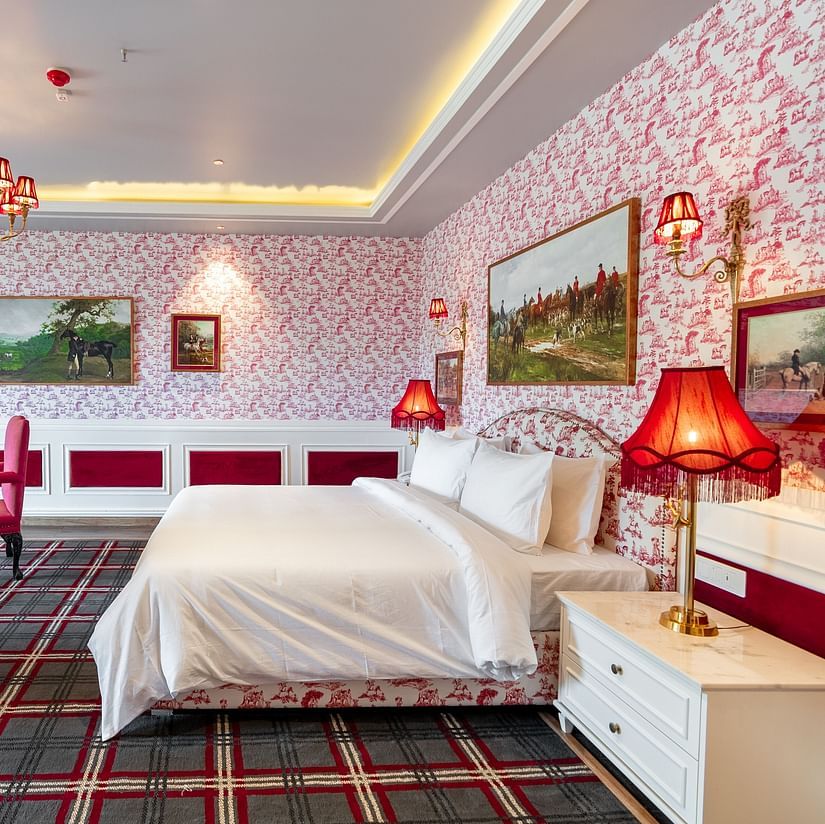 A room with a large bed and two comfy chairs in front of it  - The Manor Luxury Hotel, Shimla