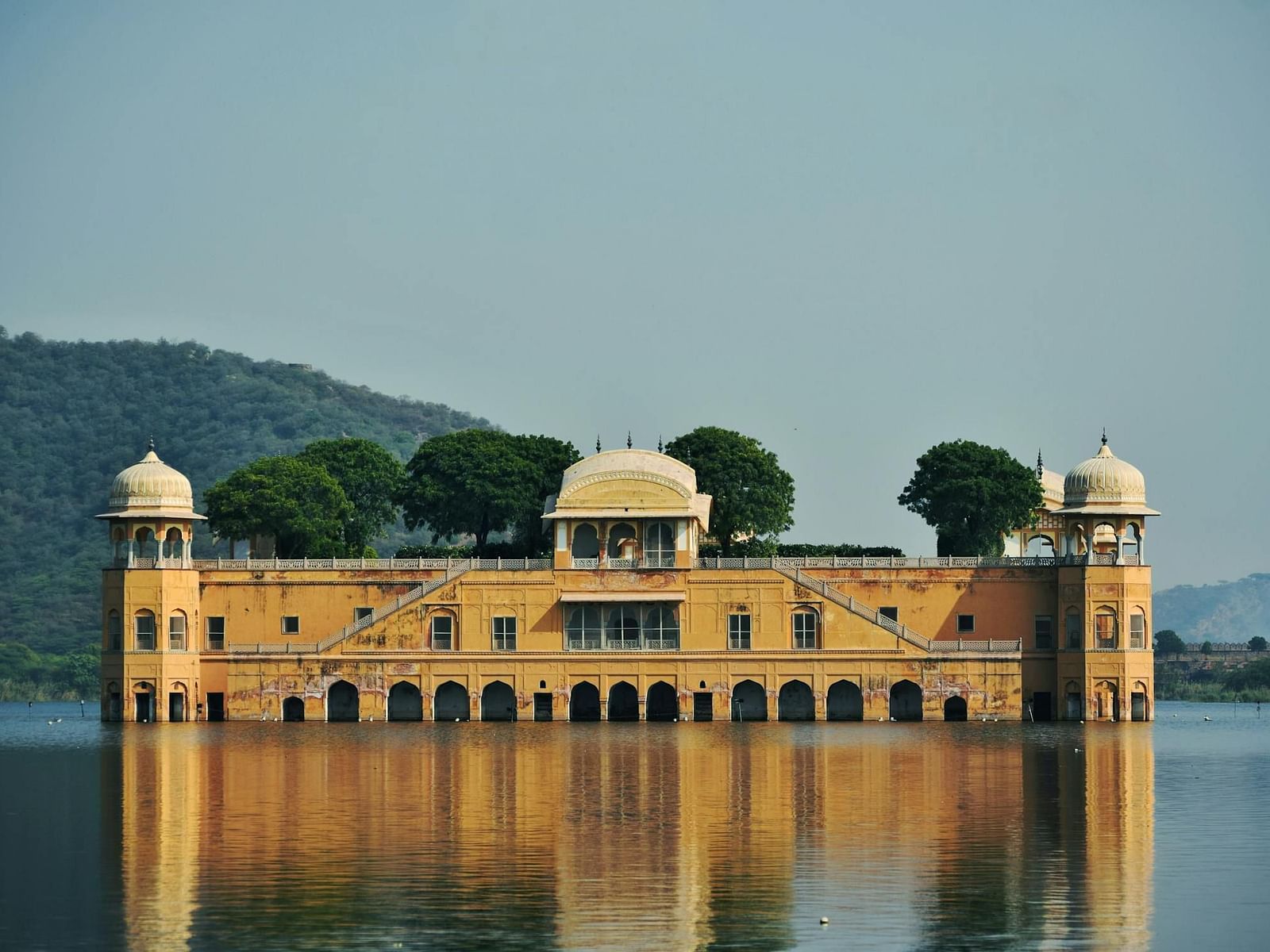 An elaborate structure with arched openings and domed towers stands partially submerged in water.