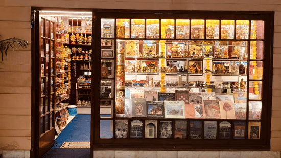 The exterior of a hotel gift shop with glass windows showing books and souvenirs on shelves | HHI Varanasi