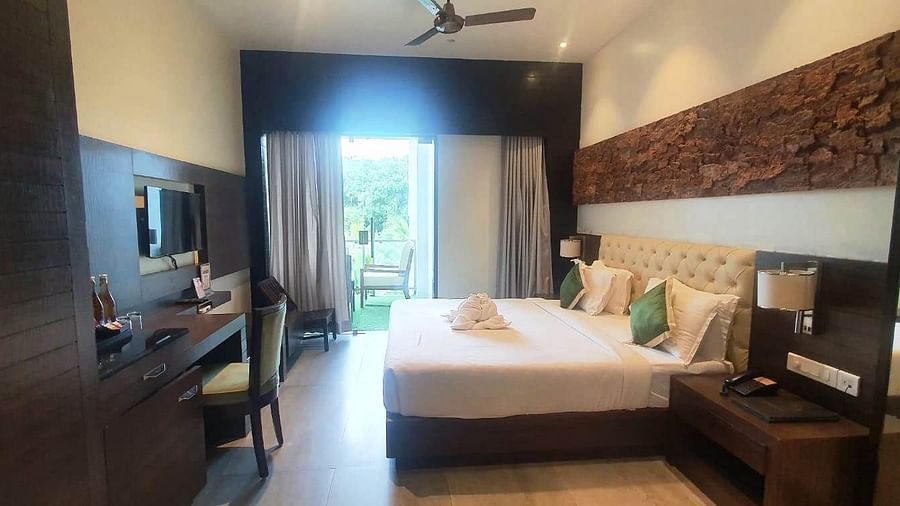 A modern hotel bedroom with a large bed, a television, and a desk area, featuring warm lighting and contemporary decor - Sea Hills Hotels, Sri Vijaya Puram (Port Blair)