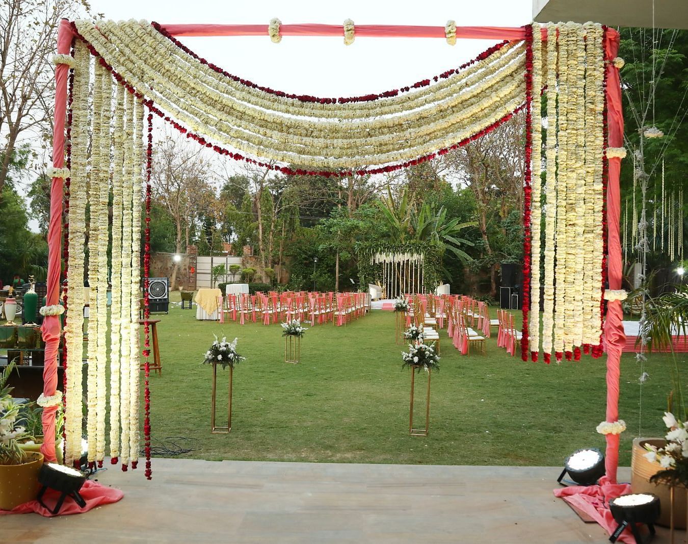 Entrance gate at Tisya Farms, Gurgaon decorated with fabric, lights, and flowers in a symmetrical arch.