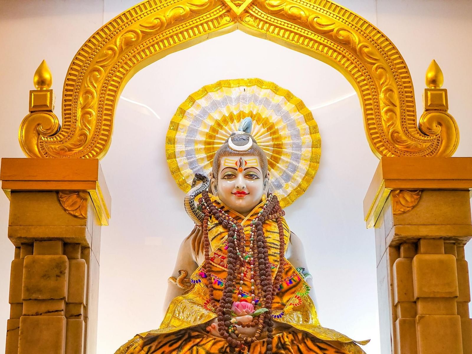 Statur of Shiva with golden borders besides it