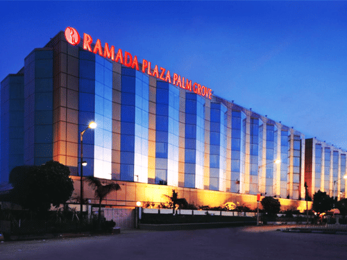 Facade view during twilight with the lights on and signage lit - Hotel Ramada Plaza Palm Grove
