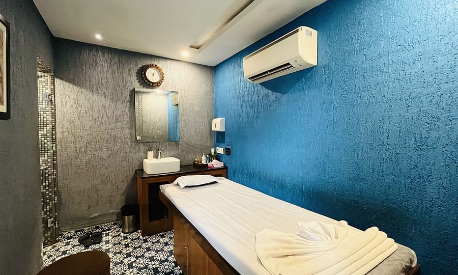 Massage room at Nemesia with a comfortable massage table and soothing painted walls.