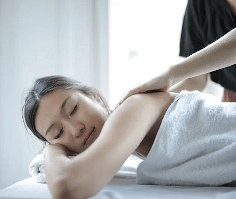 A person receiving a relaxing shoulder massage in a serene spa setting.