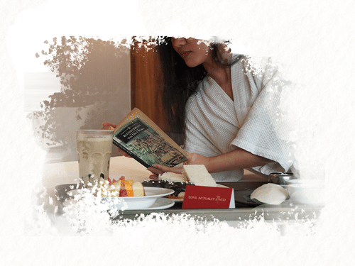 Valentine’s Day breakfast tray at Pride Hotels Group with desserts, wine and floral accents, styled for a private in-room celebration.