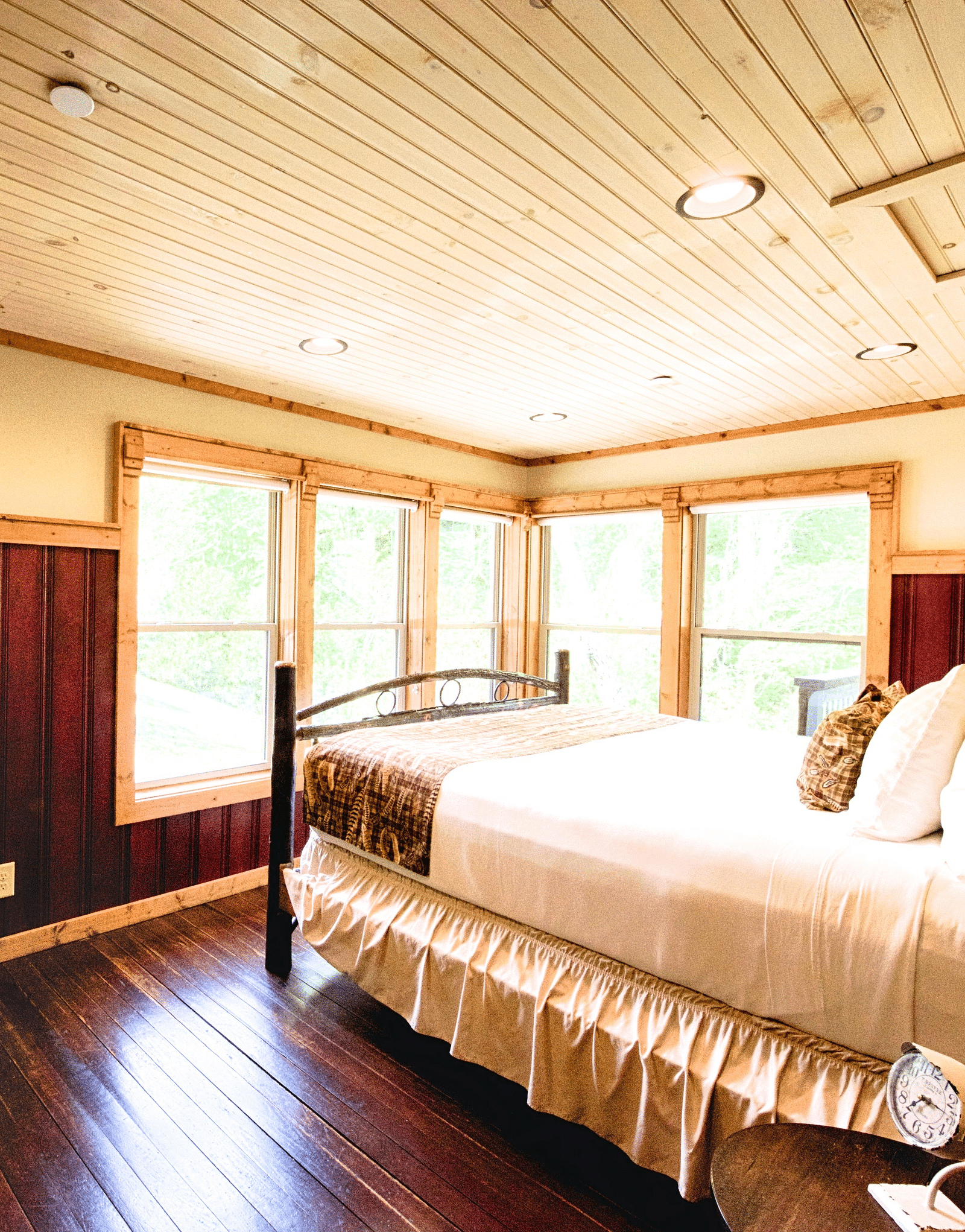 a double bed placed in front of huge windows illuminating the entire room with natural light - Historic Tapoco Lodge