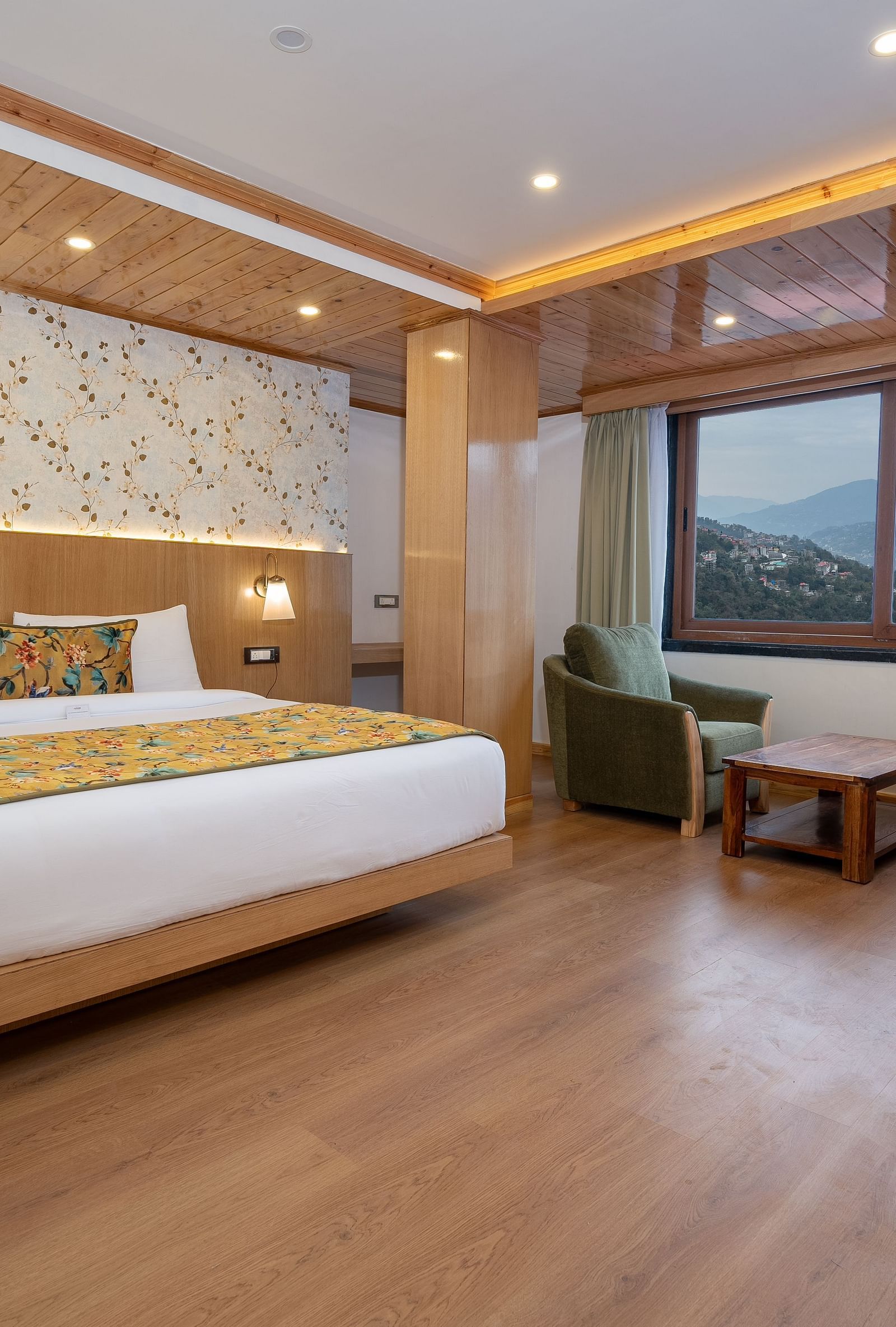 View of a king size bed and comfortable sofas near the balcony of a Premium View Room at Summit Grand Resort & Spa.