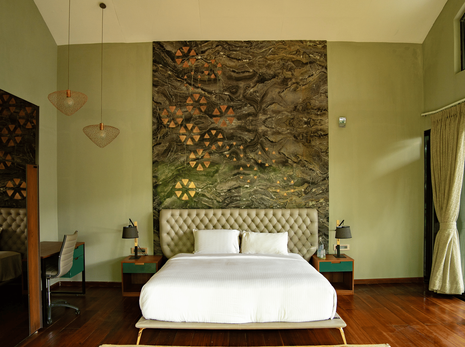 A bedroom at Stanley Revelation with a double bed, a tall tufted headboard, and decorative wall art.
