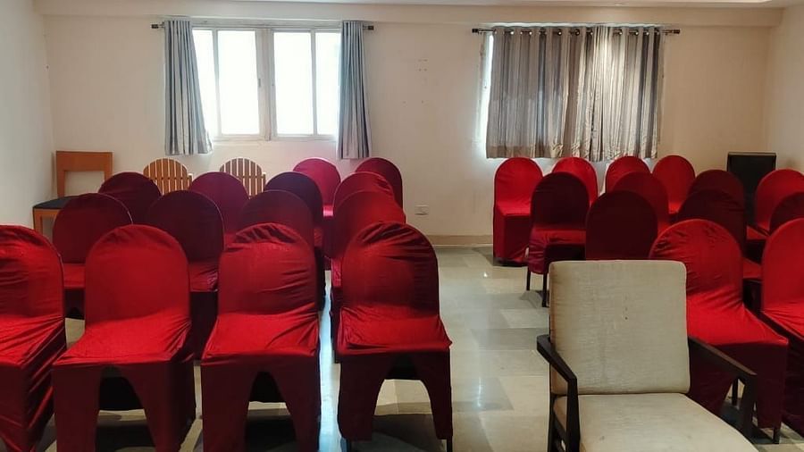 Spacious seminar hall at Lords Eco Inn Dahej featuring red fabric chairs arranged in rows with natural lighting from large windows