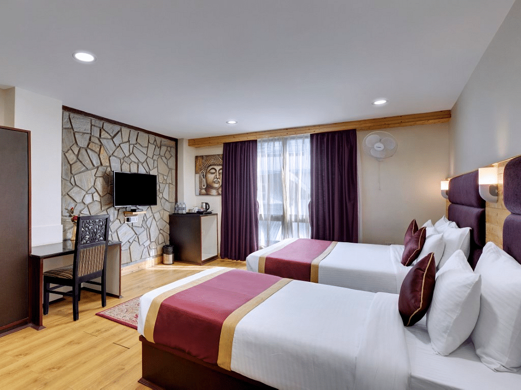An image of a room with twin bed, flat screen TV, decorative lighting - Sumitel Darjeeling