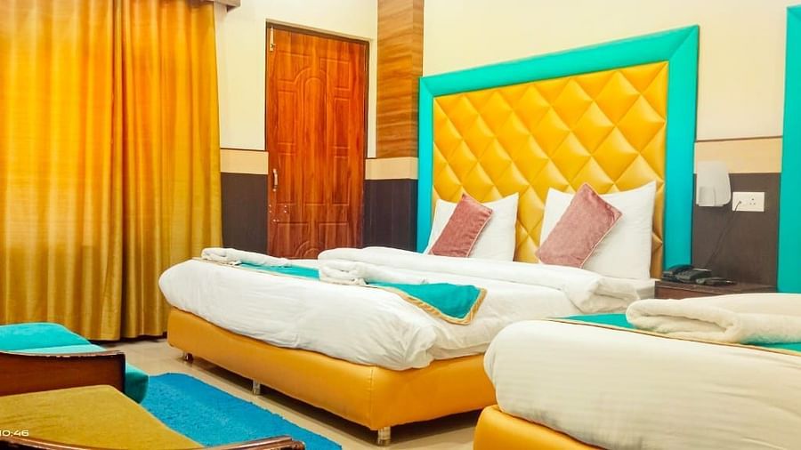 Triple Bed deluxe room with blue and white bed covers at Hotel Panchvati Inn, Joshimath