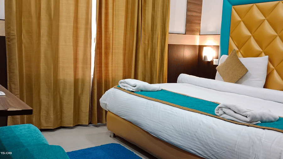 Double Bed Deluxe room with blue and white bed covers at Hotel Panchvati Inn, Joshimath