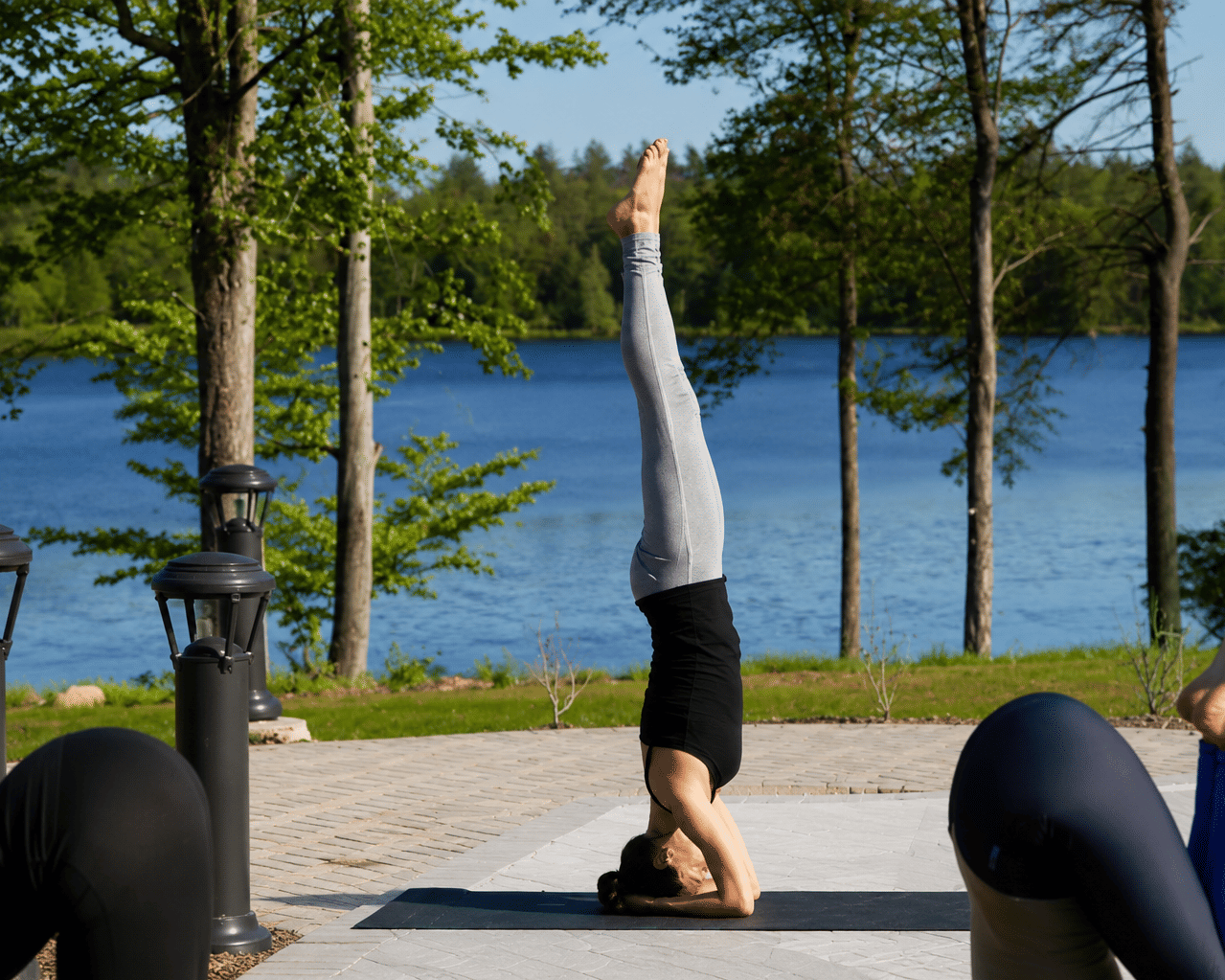 A group of people practicing yoga on a sunny patio at YO1 Longevity and Health Resorts