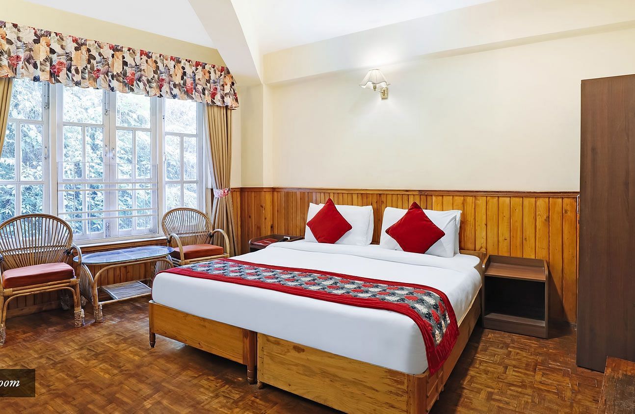 A full view of a room that has a bed and a huge glass window | Summit Newa Regency & Spa, Pelling