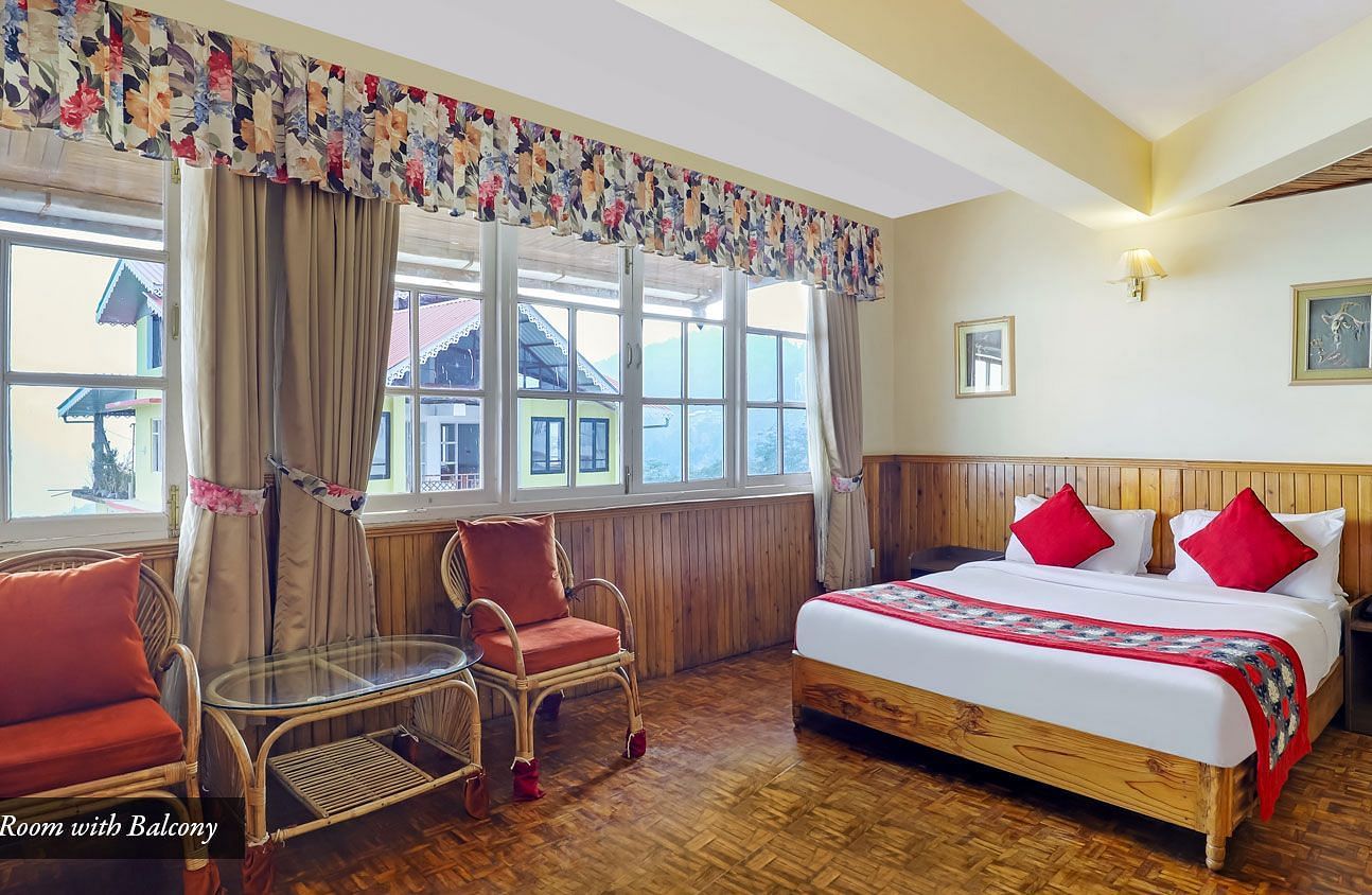A room with a bed, chairs, and a glass window | Summit Newa Regency & Spa, Pelling