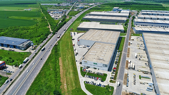 An aerial shot of buildings and grassy fields spread across divided by cement roads