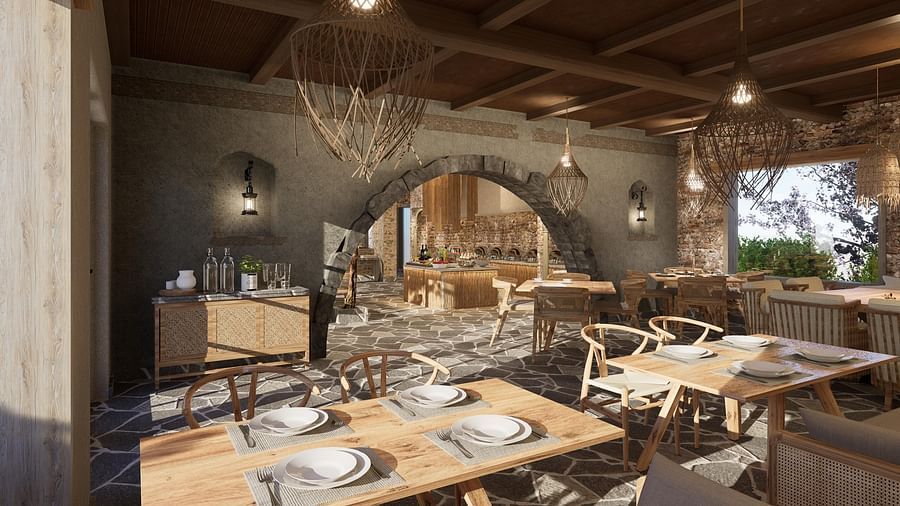 A restaurant with neatly set tables and chairs, featuring woven light decorations hanging at The Evren, Vagator.
