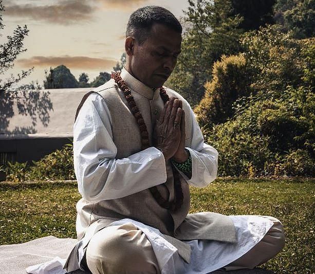 A man meditating in an open area, sitting on the grass | Kavya Resort & Spa, Nagarkot